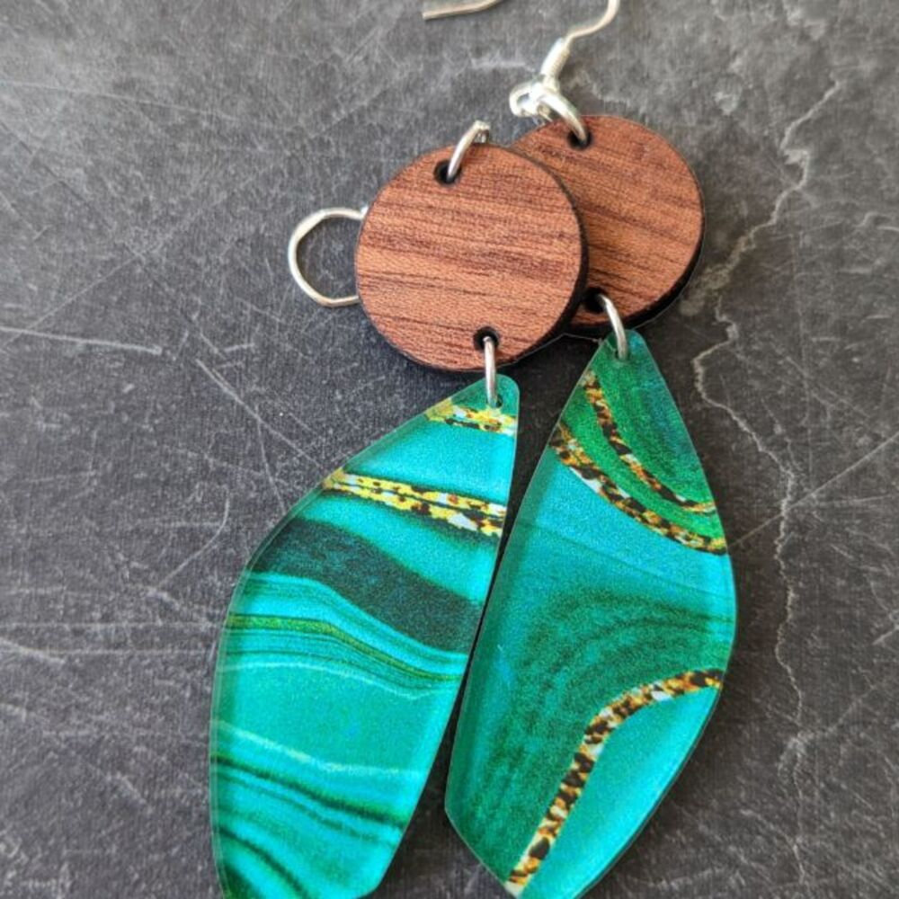 Jade and wood earrings against a dark gray granite
