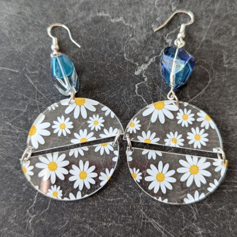 Daisy half circles earrings with bead on a dark granite background