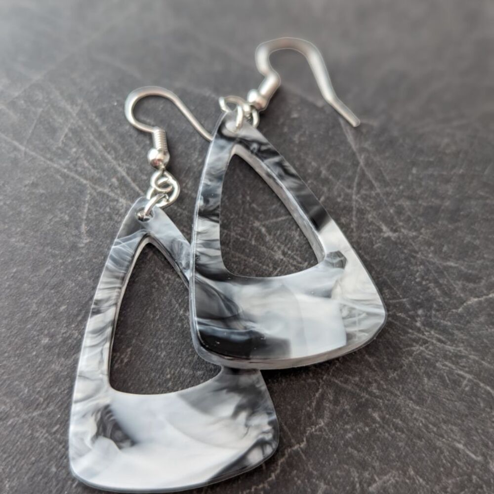 Triangular shaped black marble dangle earrings against a dark gray background