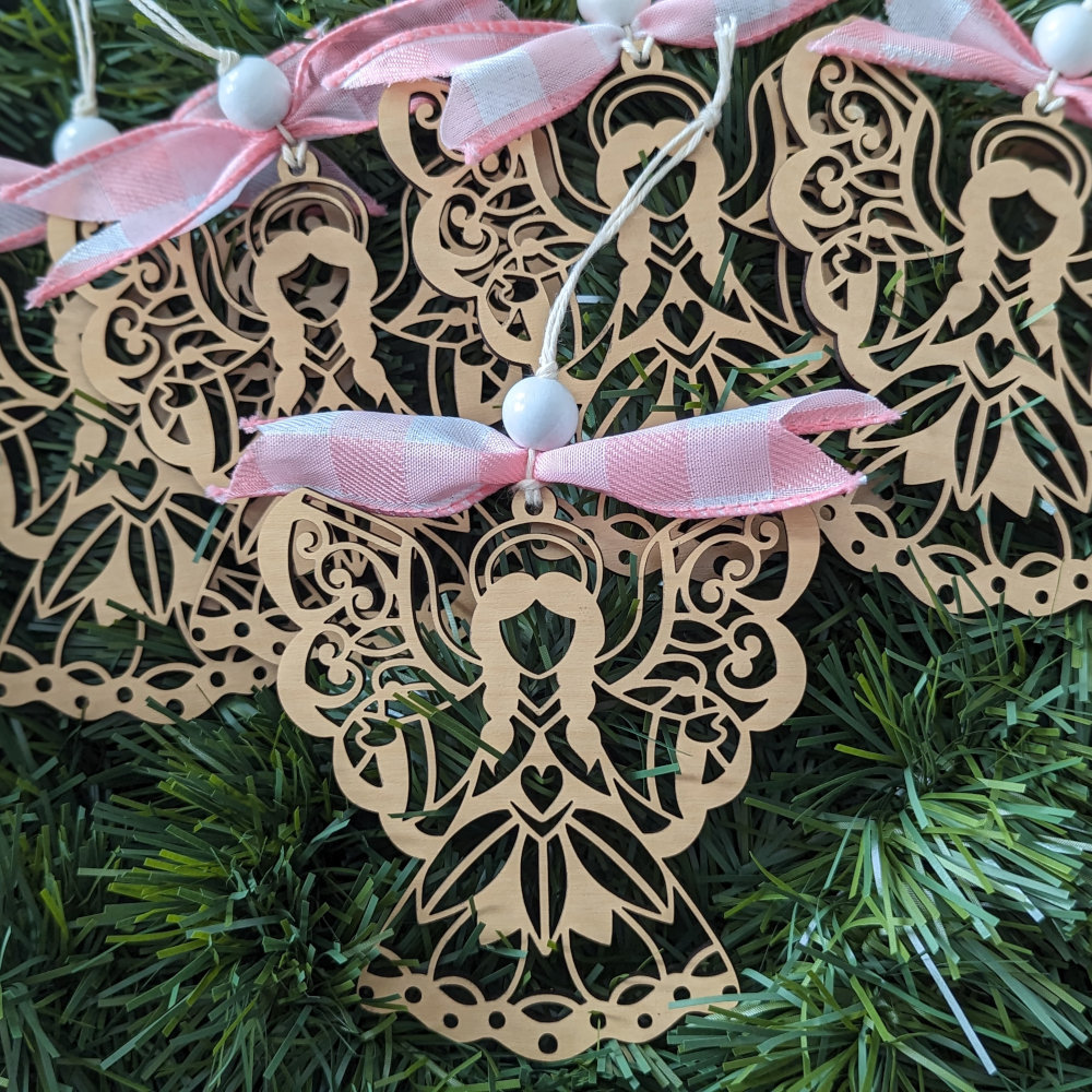 A number of Angel Ornaments with pink ribbons