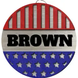 A round sign with the first 1/3 being red with cut out vertical stripes, then the name BROWN in large chunky lettering, then the final third being blue with cut out stars.