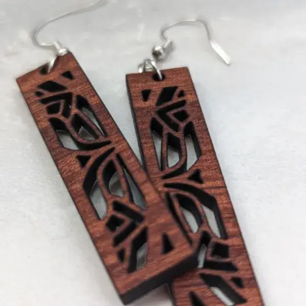 Sapele mandala earrings in front of a light granite